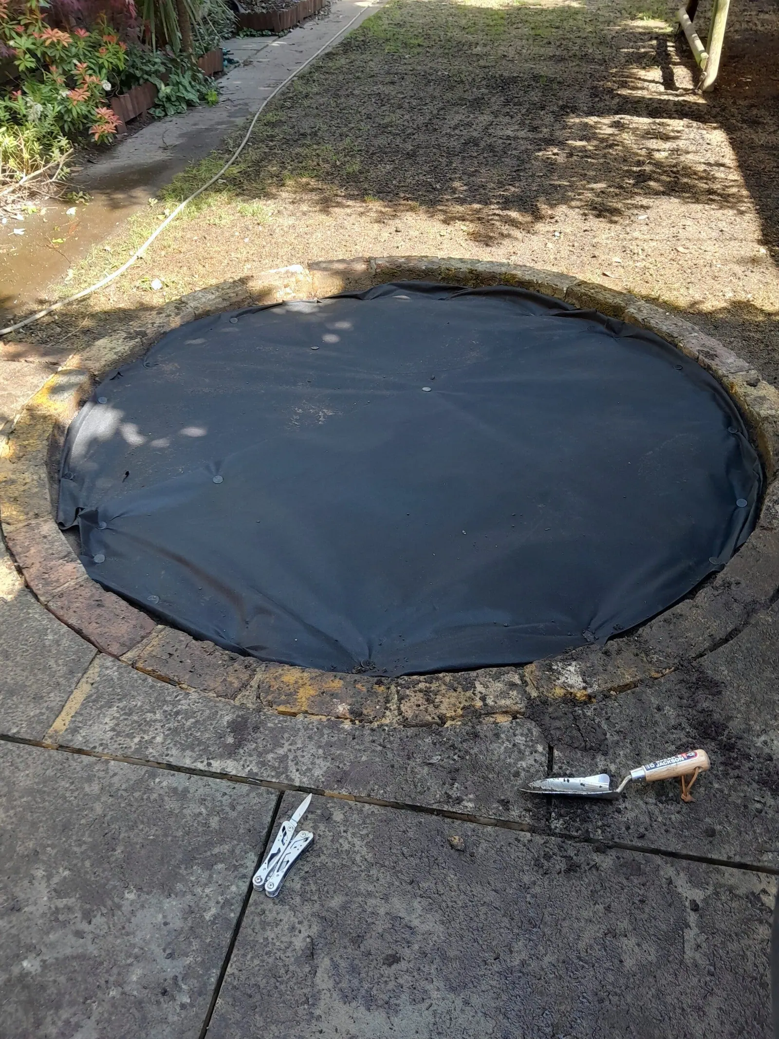 Round bed cleared and weed membrane laid ready for planting and slate